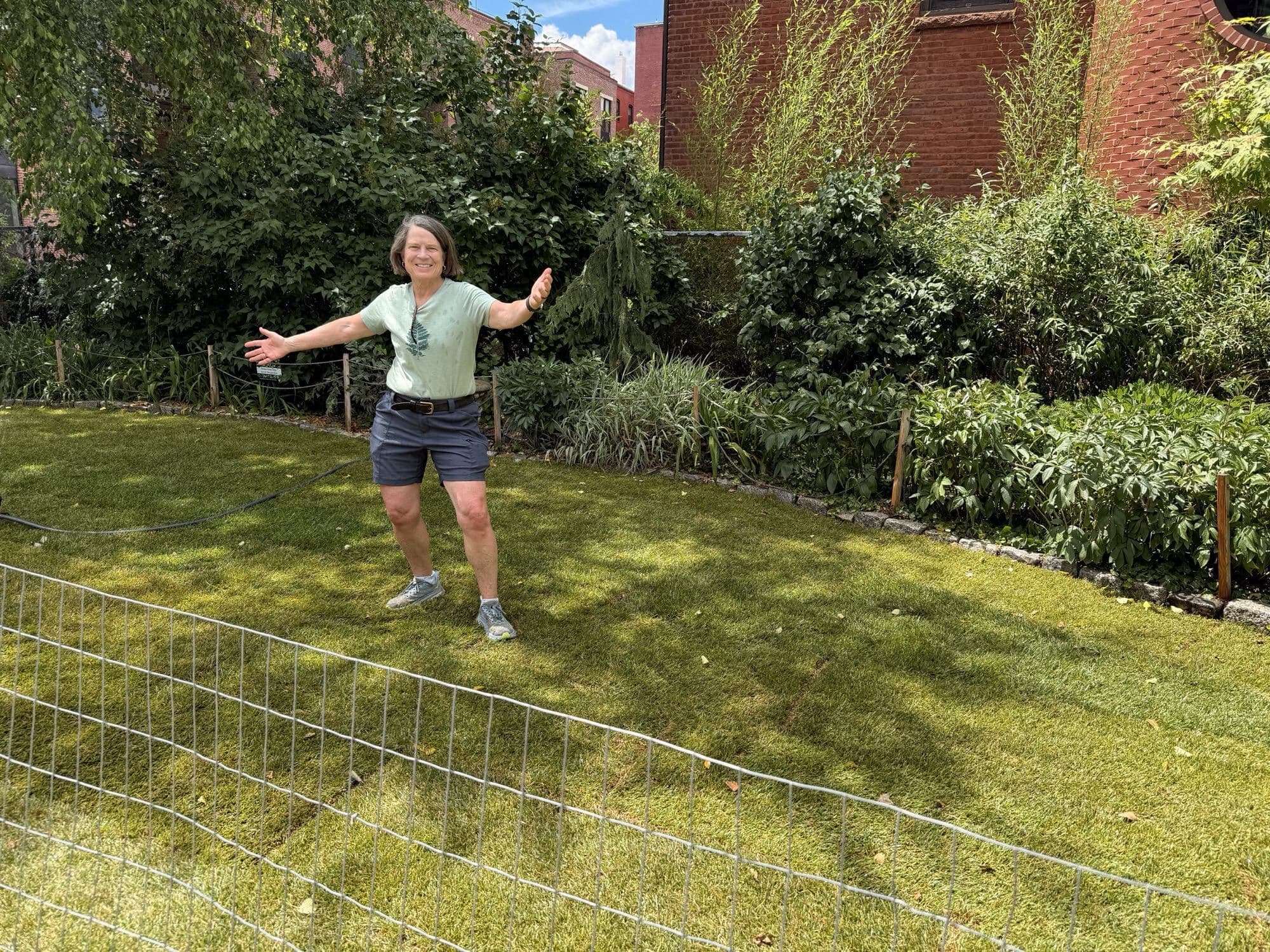 Volunteer celebrating on the newly sodded lawn